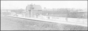 Neston South Station, circa 1950, viwed from the road bridge; note the train passing over the Station Road bridge heading for Neston North.
