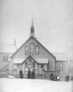 The iron Mission Hall, replaced in 1907 by Neston Methodist Church. Police station/Court House on the left.