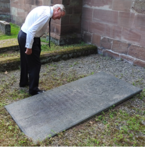 Ben Stephenson, a grandson of Billy Congreve, examining the memorial stone on the Congreve vault in Burton churchyard.